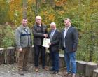Offizielle Übergabe des Zuwendungsbescheids am Walderlebniszentrum Gramschatzer Wald (von rechts nach links: Harald Fröhlich (Geschäftsführer der LAG), Burkhard Losert (Vorsitzender des Fördervereins), Wolfgang Fuchs (Leader-Koordinator) und Wolfgang Graf (Leiter des Walderlebniszentrums).